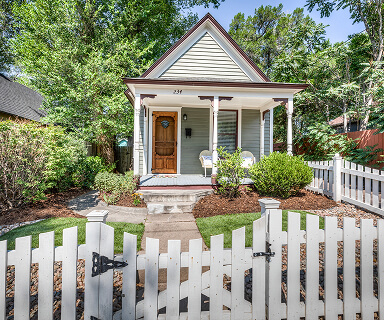 Two-story craftsman home with covered front porch and lush landscaping in a quiet Colorado Springs neighborhood | Logo Inc Real Estate
